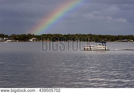 Under A Beautiful Rainbow, A Patriotic Pontoon Boat Moves Across The Waters Of Lake Conway, Belle Is