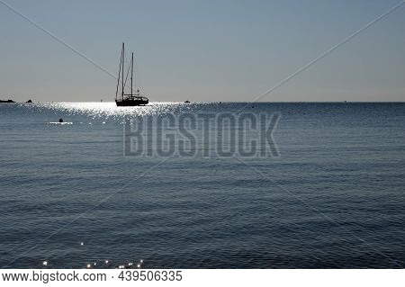Sailboat At Anchor In Summer, Calm Sea In France , Blues Ky And Sun Reflexes