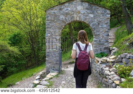 Young Backpacker Under An Archway Door. Civate, Italy