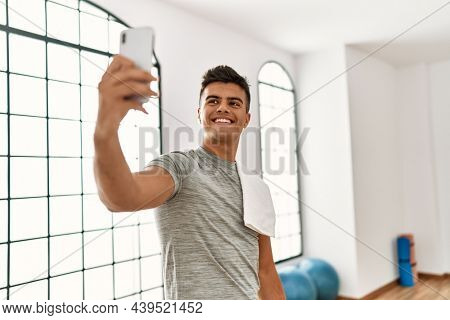 Young hispanic man smiling confident make selfie by the smartphone at sport center