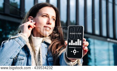 Audio Tour Online App On Digital Mobile Smartphone. Happy Young Student Woman Holding Phone Listenin