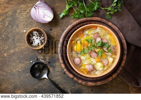 Czech Food: Traditional Zelnacka Cabbage Soup With Sausages And Vegetables In A Bowl On Rustic Woode