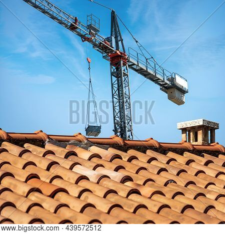 Gray And Red Crane And A Closeup Of A Roof With Terracotta Tiles (coppo In Italian Language) On Clea