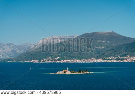 Island Of Otocic Gospa In The Bay Against The Backdrop Of The Town On The Coast. Montenegro
