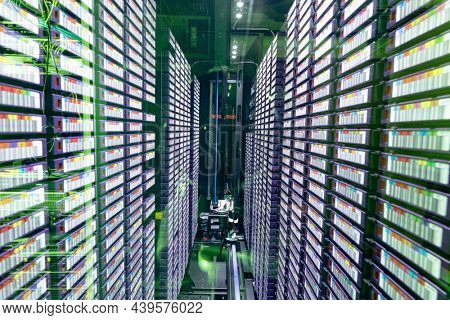 Data center with multiple rows of fully operational server racks. modern cloud computing technology concept.