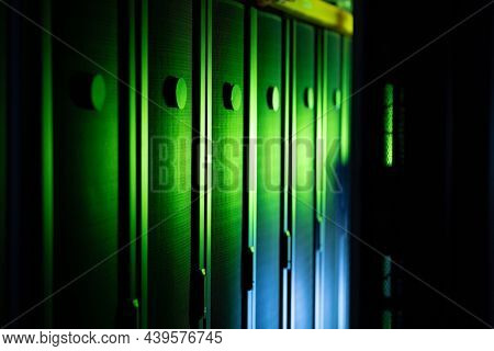 Data center with multiple rows of fully operational server racks. modern cloud computing technology concept.