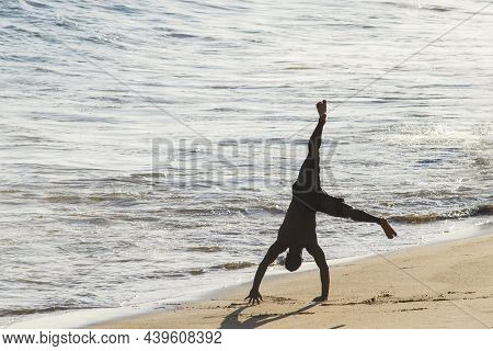 Salvador, Bahia, Brazil - January 05, 2019: Man Does Marbalism In The Sands Of Paciencia Beach, In R