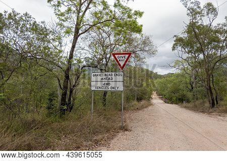 Signage On A Country Dirt Road Warning That The Gravel Road Ends Ahead And To Give Way To Traffic
