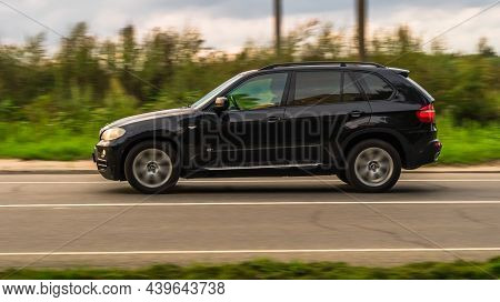 Moscow, Russia - August 2021: Black Bmw X5 E70 Driving On The Country Road With Blurred Nature Backg