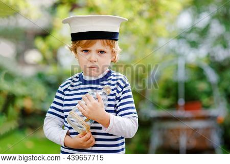 Sad Crying Little Kid Boy In Sailor Capitain Hat And Uniform Playing With Sailor Boat Ship. Upset Pr