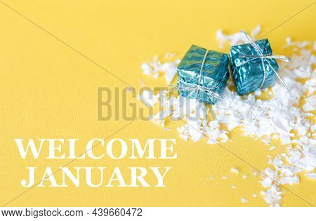 Welcome January Text On Yellow Yon Next To Two Gifts In A Package