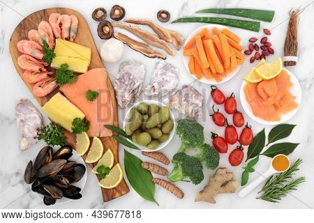 Immune system boosting health food collection. Seafood, vegetables, fruit, medicinal herbs and spice. Foods high in antioxidants, anthocyanins, protein, fibre, vitamins, minerals, omega 3. Flat lay.