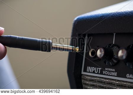 Close-up Of An Unrecognizable Person Introducing The Jack Cable On An Electric Amplifier. Music, Aud