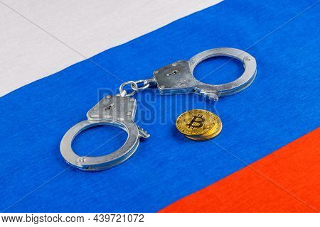 Roll Of Russian Paper Rubles Currency And Bitcoin Shiner Chained With Handcuffs On Russian Flag Back