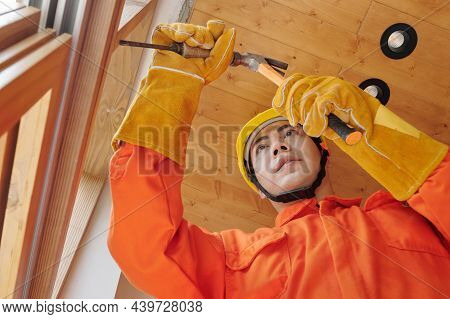 Concentrated Young Vietnamese Builder Using Hammer And Chisel When Working On House Rennovation