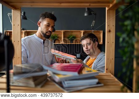 Young Happy Man With Down Syndrome And His Tutor Indoors At Staffroom.