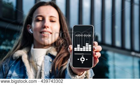 Audio Excursion Online App On Digital Mobile Smartphone. Happy Young Student Woman Holding Phone Lis