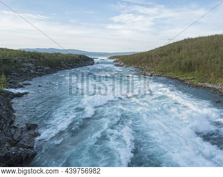 Blue Wild Water Of Vuojatadno River Rapids And Mouth To Akkajaure Lake, Rocks And Birch Tree Forest 