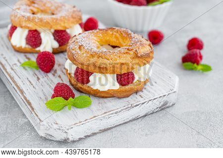 Choux Pastries. Choux Rings With Cream Of Cream Cheese Or Cottage Cheese And Fresh Raspberries, Dust