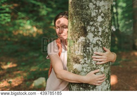 Woman Is Hugging Tree Trunk In Forest, Female Environmentalist With Her Arms Around The Tree, Select