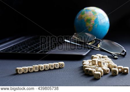 Esperanto Inscription Next To An Open Laptop, Glasses And Globe. The Concept Of Modern Technologies 