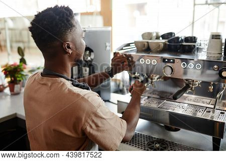 Unrecognizable African American Barista Adjusting Settings On Professional Coffee Machine For Making