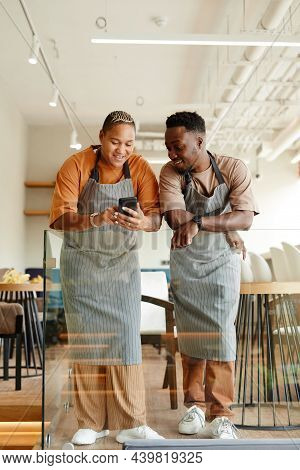 Vertical Full Length Shot Of Young African American Man And Woman Working Together In Modern Cafe Wa
