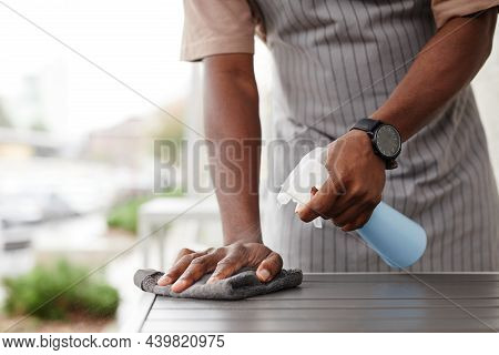 Close-up Shot Of Unrecognizable Black Man Wearing Apron Working In Cafe Preparing Tables Outdoors Fo