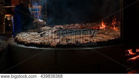 Spare Ribs Cooking On Barbecue Grill. Grill Restaurant Open Kitchen. Chef Cooking Ribs In Bbq