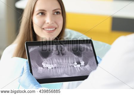 Portrait Of Dental Consultation In Clinic And Doctor Examine Teeth X Ray On Digital Tablet Screen. S