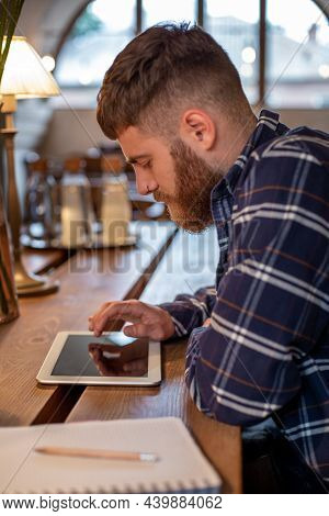 Freelancer Dressed In Casual Outfit Focus On Reading News And Looking On Digital Tablet While Sittin