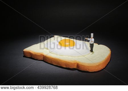 The Mini Chef Stand On The Fried Egg On A Piece Of  Bread