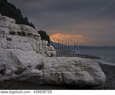 Beautiful Beach With White Rocks At Sunset With Sunbeams Over The Sea