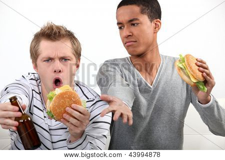 Přátelé jíst hamburgery a sledovat fotbalový zápas