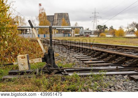 Photo Of A Railway Track And A Railway Direction Switch. Railway Arrow, On The Background Of The Hea