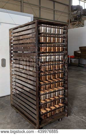 Metal Racks With Freshly Baked Loaves Of Fresh Wheat Bread. Fresh Bread On A Mobile Rack With Shelve