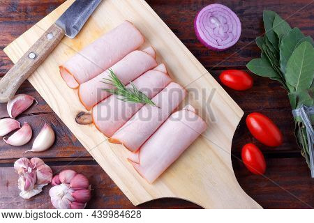 Sliced Cold Smoked Turkey Breast Over Rustic Wooden Table