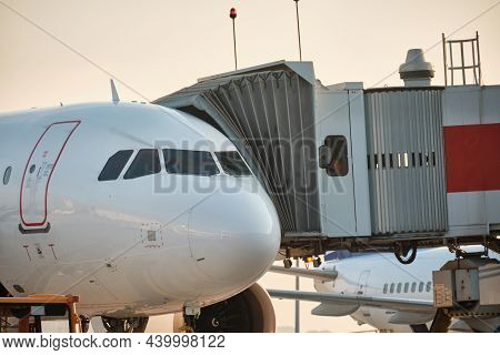Plane With Jetway In The Evening. Passenger Boarding. Airport Ground Service And Maintenance. Boardi