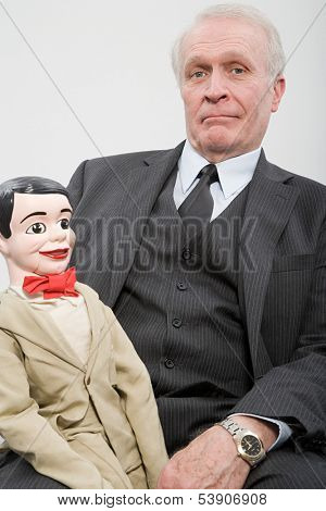 Businessman holding ventriloquists dummy