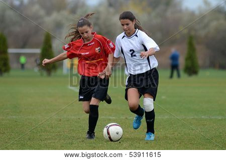 KAPOSVAR, HUNGARY - NOVEMBER 3: Dorisz Druzsin (in white) in action at  a Hungarian Championship under 15 women soccer game Rakoczi FC (white) vs Pecsi MFC (red) November 3, 2013 in Kaposvar, Hungary.