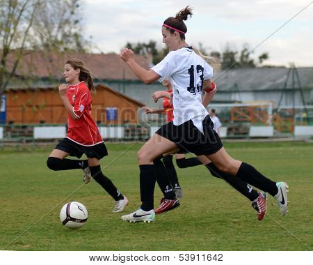 KAPOSVAR, HUNGARY - NOVEMBER 3: Kata Recsei (white 13) in action at Hungarian Championship under 15 women soccer game Rakoczi FC (white) vs Pecsi MFC (red) November 3, 2013 in Kaposvar, Hungary.