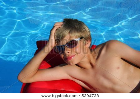 Ragazzo sorridente sul materassino In piscina
