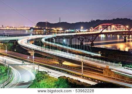 Night scene of cars light at highway and interchange in famous Guandu Bridge, Taipei, Taiwan, Asia.