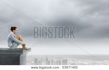 Image of young attractive businesswoman sitting alone atop of building