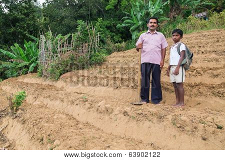 ELLA, SRI LANKA - MARCH 2, 2014: Local farmer and his son stand on tea plantation. Ella is famous for the tea plantations and stunning views across the countryside.