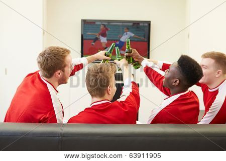 Group Of Sports Fans Watching Game On TV At Home