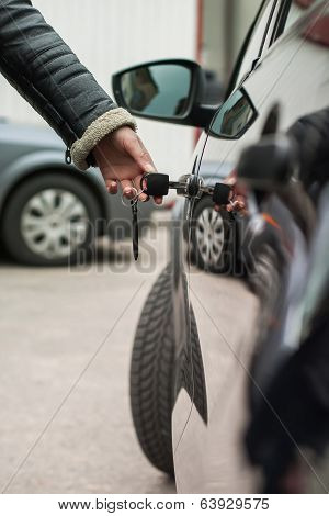 Hand with key opens car door