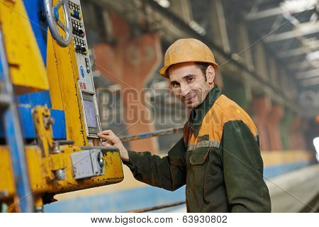 industrial worker operating concrete machine at factory workshop