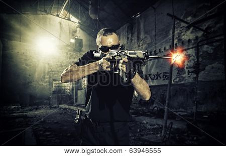 man shooting a gun and wearing sunglasses