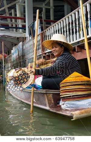 RATCHABURI, THAILAND - MARCH 24: Local peoples sell fruits, food and souvenirs at famous tourist attraction Damnoen Saduak floating market on March 24, 2014 in Ratchaburi, Thailand.